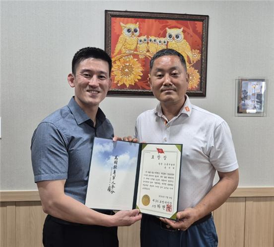 8087부대 1대대 김기형 대대장이 손기택(오른쪽) 한국드론기술원 이사장에게 육군 제36보병사단장 표창장을 전달하고 기념사진을 찍고 있다.[한국드론기술원 제공]