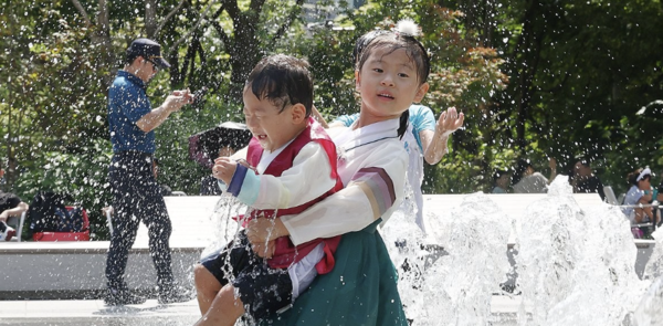 추석 연휴인 지난 16일 서울 종로구 광화문광장 바닥분수대에서 한복을 입은 어린이들이 무더위를 피해 시원한 시간을 보내고 있다.[연합뉴스]