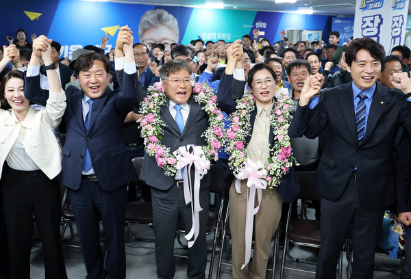 10ㆍ16 재ㆍ보궐선거가 실시된 16일 오후 전남 영광군수 재선거에서 당선이 확실시된 더불어민주당 장세일 후보가 배우자 정수미 씨와 화환을 목에 걸고 지지자들에게 인사하고 있다. [연합뉴스]