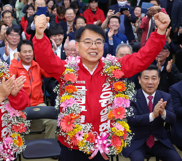 윤일현 국민의힘 금정구청장보궐선거 후보가 16일 오후 부산 금정구 선거사무소에서 당선이 유력해지자 꽃다발을 목에걸고 환호하고 있다. [연합뉴스]